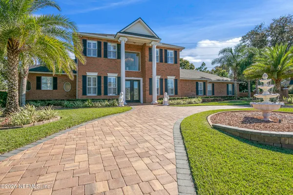 a front view of a house with a yard and potted plants