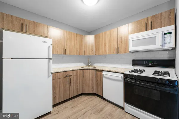 a kitchen with a refrigerator sink and cabinets