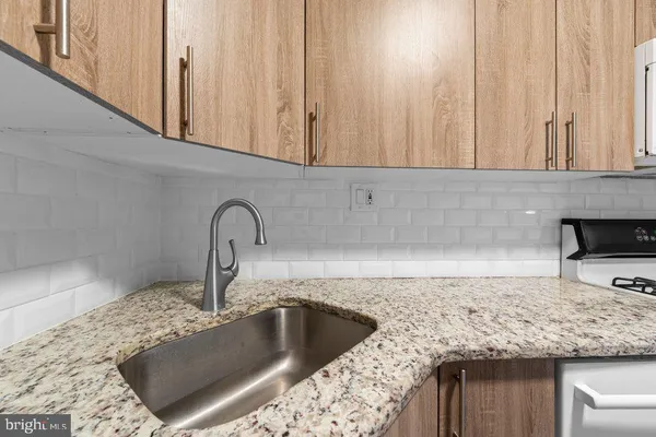 a kitchen with granite countertop a sink and a stove