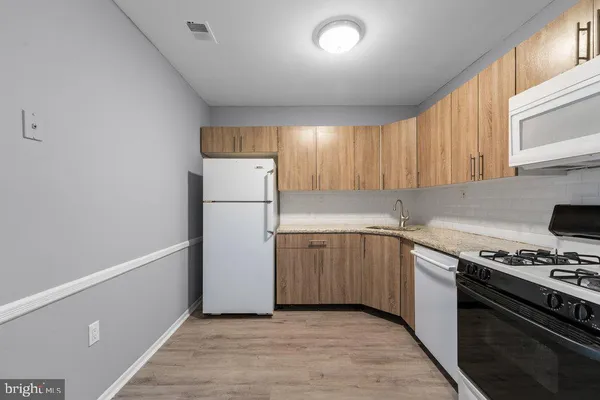a kitchen with a refrigerator and a stove top oven
