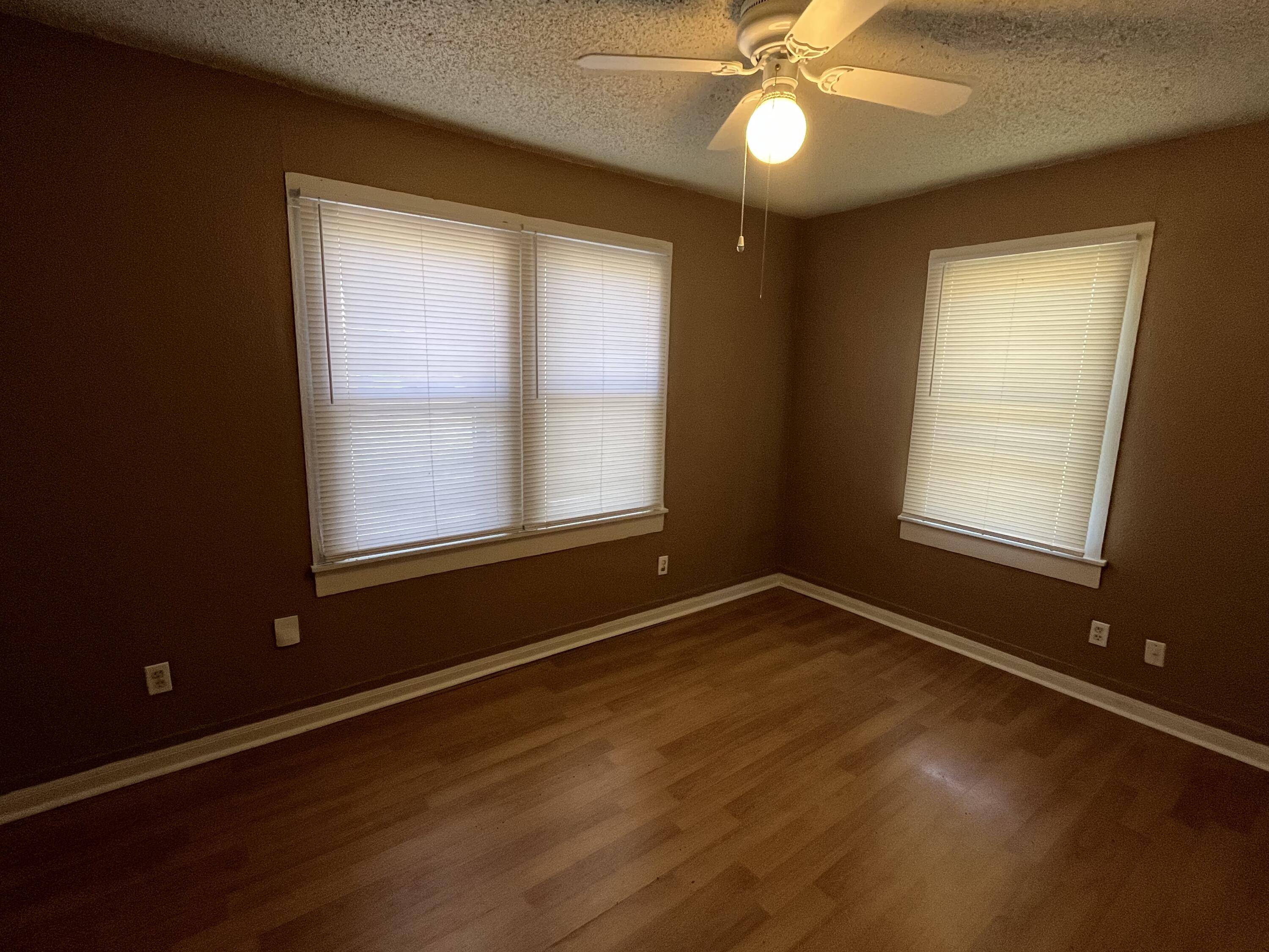 2111 25th Street Lubbock, TX 79411 - Photo 6 of 8 a view of an empty room with window and wooden floor