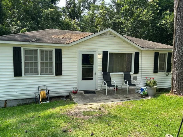 a view of a house with a yard chairs and a table