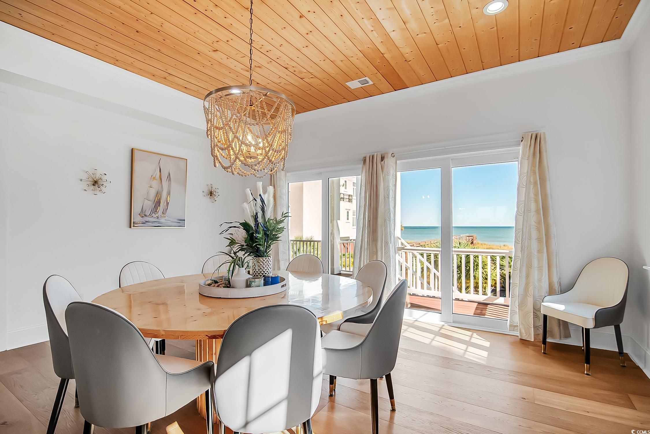 139 Pioneer Loop Georgetown, SC 29440 - Photo 15 of 39 Dining space with wood finished floors, a chandelier, a water view, and wooden ceiling