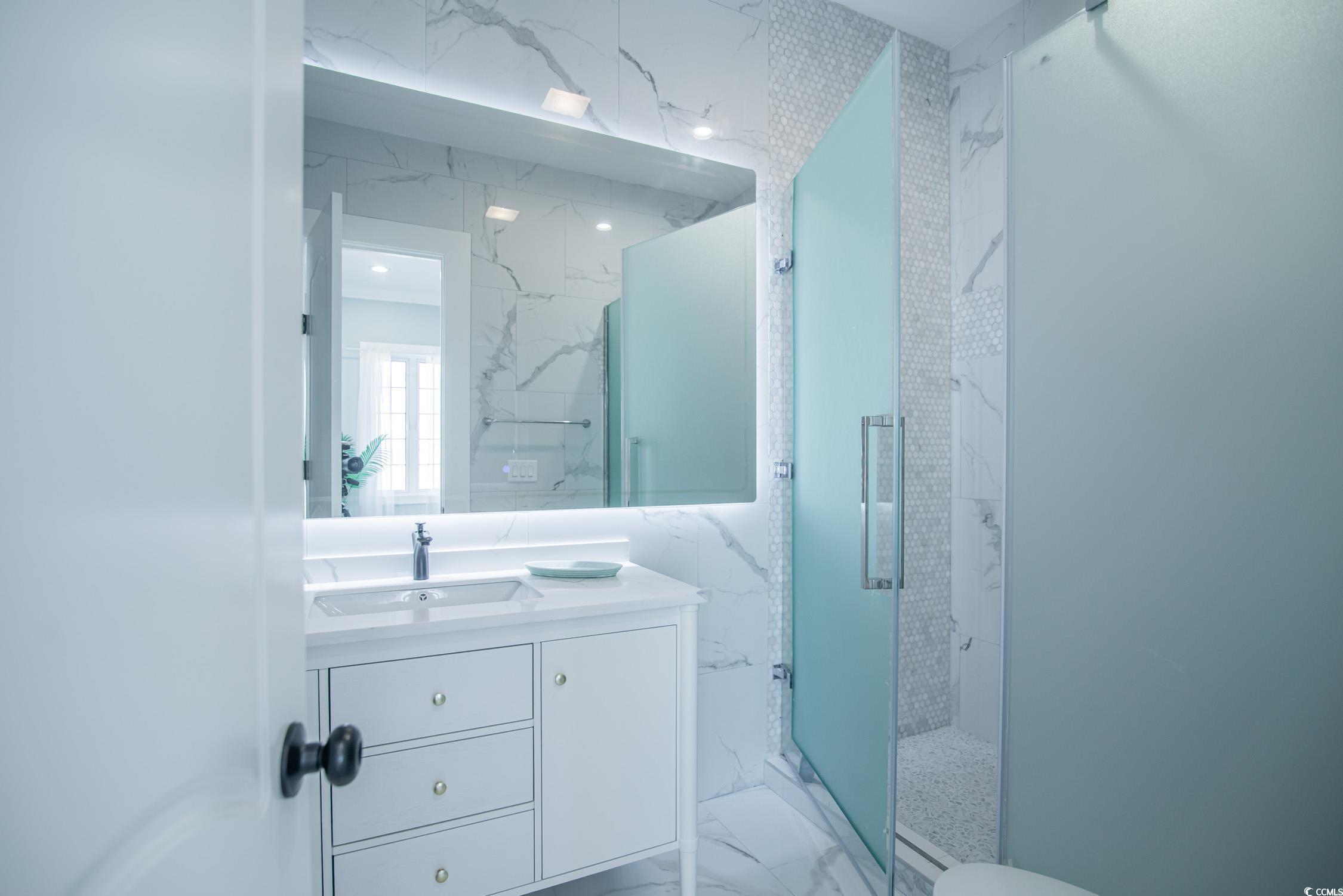 139 Pioneer Loop Georgetown, SC 29440 - Photo 30 of 39 Full bath featuring light marble finish floors, vanity, and a marble finish shower