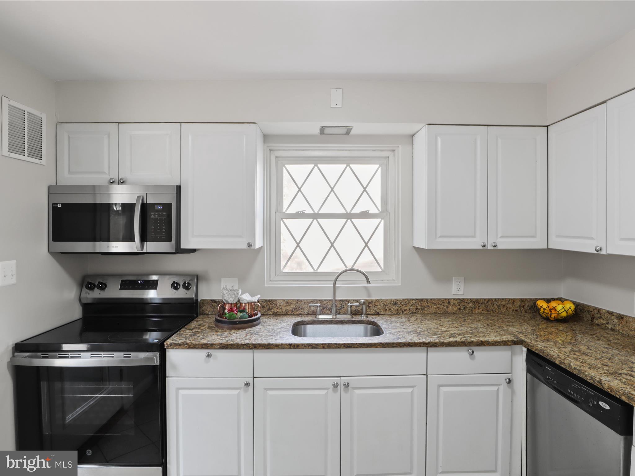 3106 63rd Place Cheverly, MD 20785 - Photo 12 of 42 a kitchen with granite countertop a sink a stove and cabinets