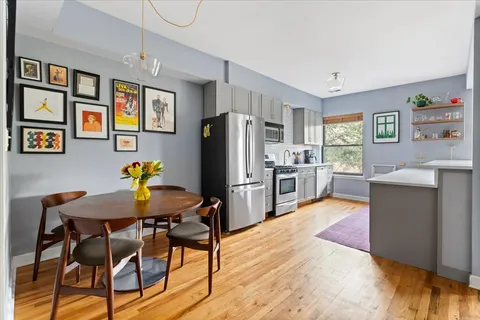 a kitchen with stainless steel appliances wooden floor and refrigerator