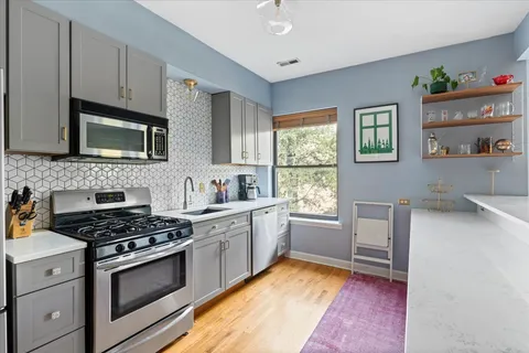 a kitchen with cabinets appliances and a window