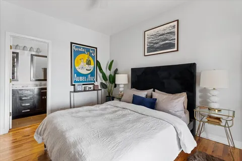 a bedroom with a bed and wooden floor