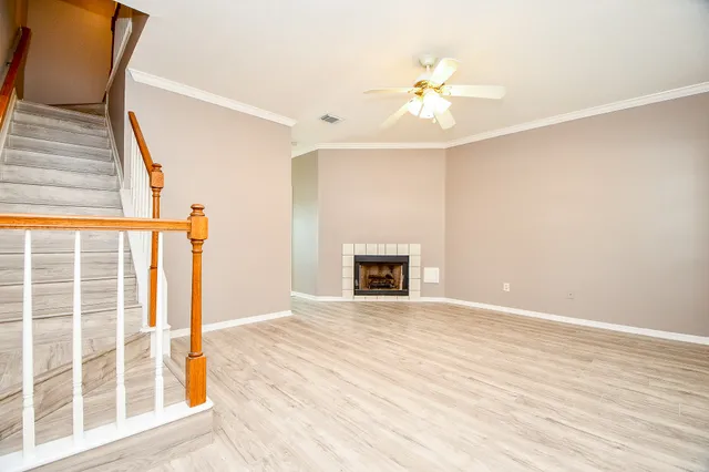 a view of an empty room with a fireplace and a window