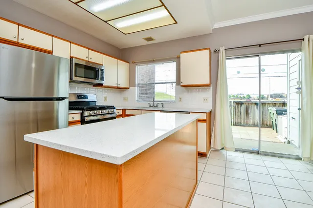a kitchen with stainless steel appliances a refrigerator sink and microwave