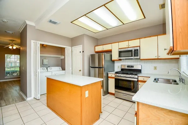 a kitchen with stainless steel appliances granite countertop a stove a sink and a microwave