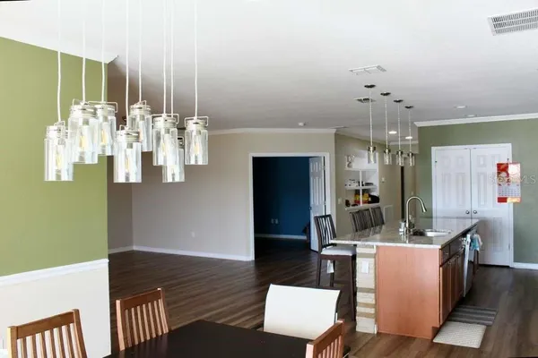 a room with lots of white furniture and chandelier