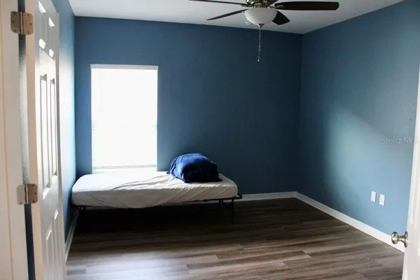 a bedroom with a bed and a ceiling fan
