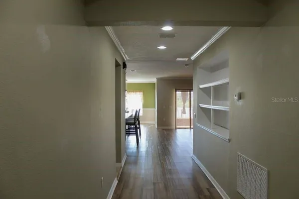 a view of empty room with wooden floor