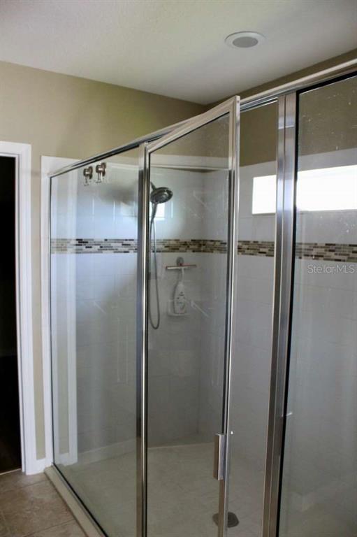 1408 Lanier Point Place Kissimmee, FL 34746 - Photo 19 of 31 a bathroom with a glass shower door