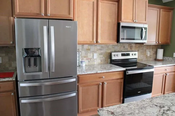 a kitchen with stainless steel appliances granite countertop a refrigerator stove and sink