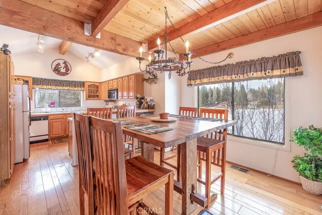 a view of a dining room with furniture a chandelier and wooden floor