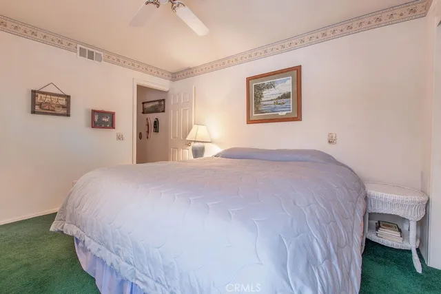 a spacious bedroom with a bed and a chandelier