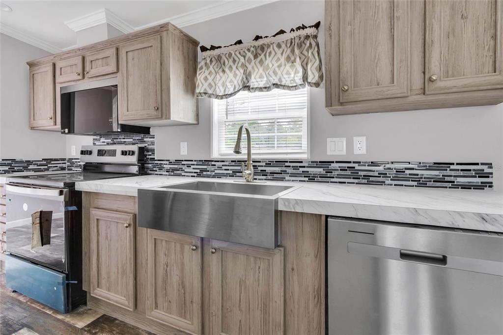 3264 Stephens Boulevard Spring Hill, FL 34606 - Photo 11 of 35 a kitchen with stainless steel appliances a sink stove and microwave