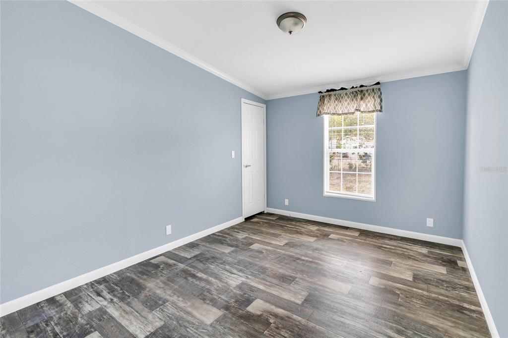 3264 Stephens Boulevard Spring Hill, FL 34606 - Photo 19 of 35 an empty room with wooden floor and windows