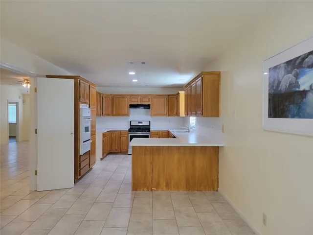 a kitchen with stainless steel appliances a refrigerator and a stove top oven