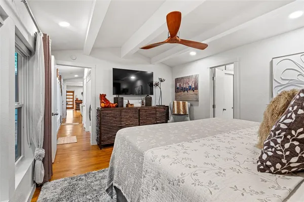 a bedroom with a bed and a flat tv screen on wall