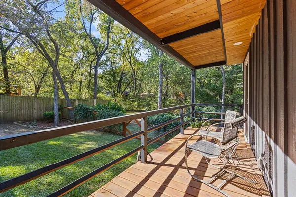 a view of balcony with wooden floor and fence