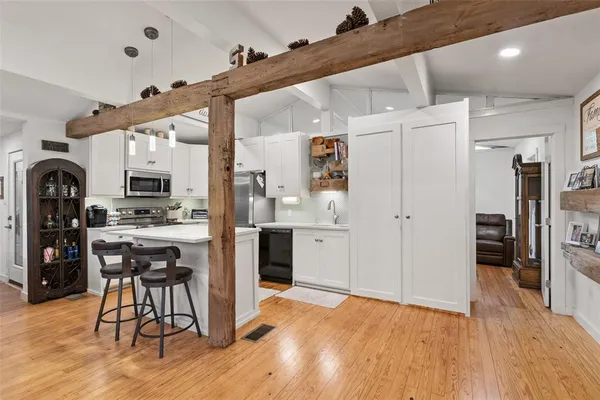 a view of kitchen with refrigerator microwave and wooden floor