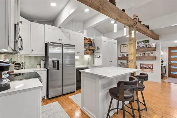 a kitchen that has a lot of cabinets a sink and appliances in it