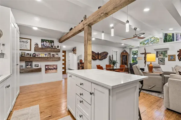 a large white kitchen with lots of counter space and refrigerator