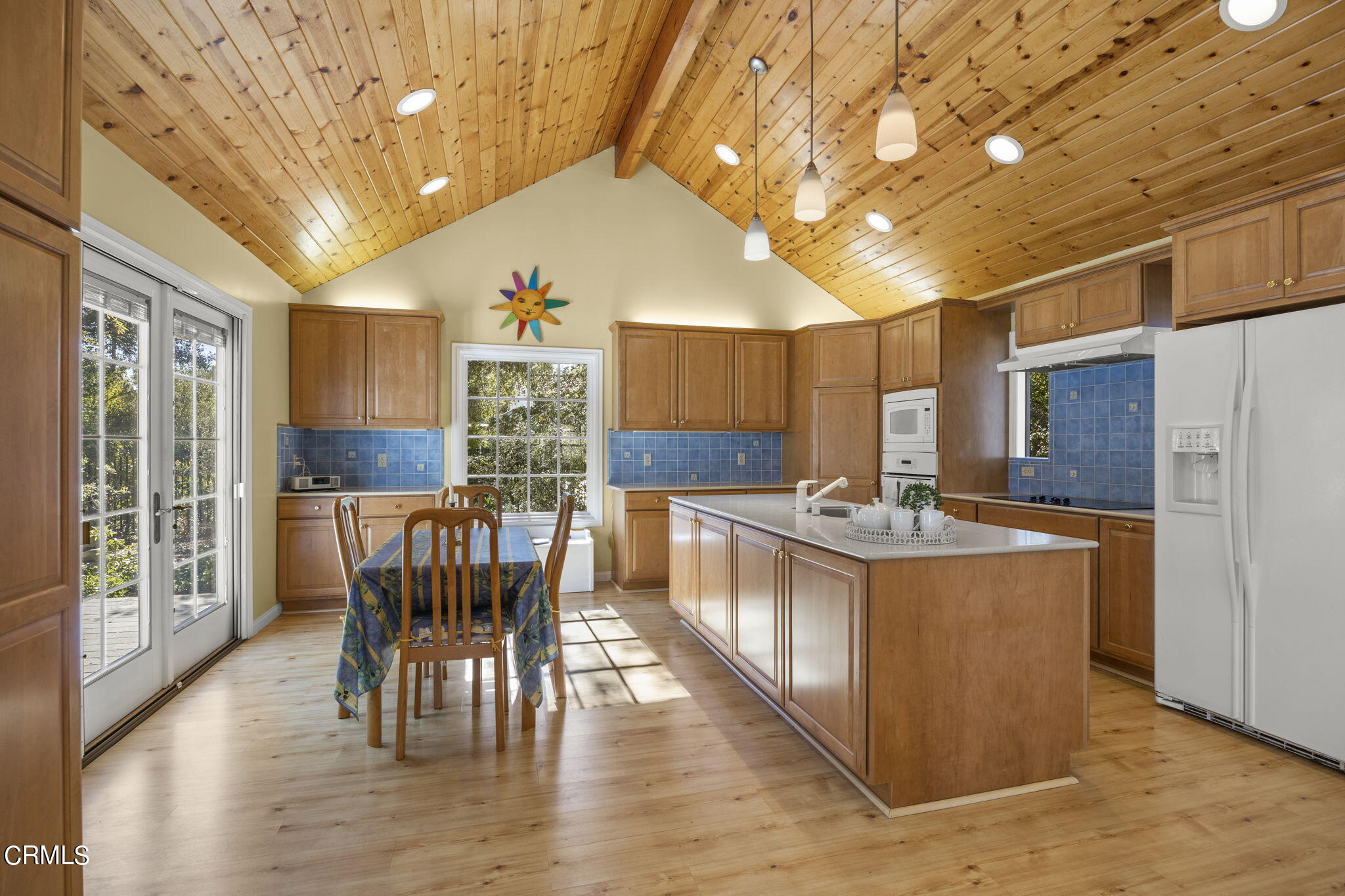 601 Foothill Road Ojai, CA 93023 - Photo 12 of 47 a kitchen with stainless steel appliances granite countertop a stove a refrigerator a microwave oven with a dining table and chairs with wooden floor