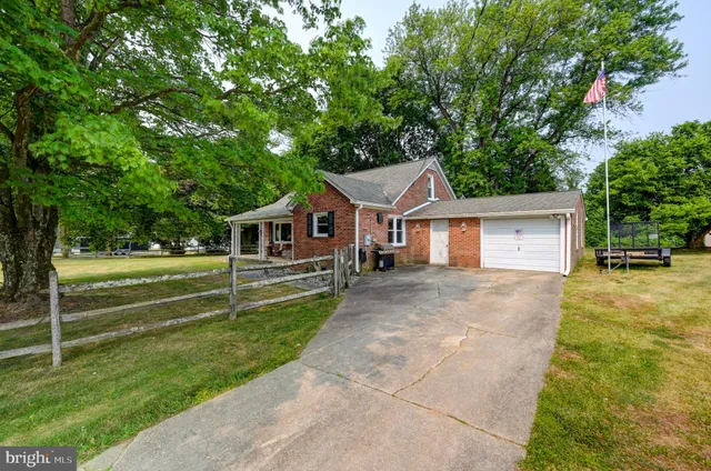 a front view of a house with a yard and trees