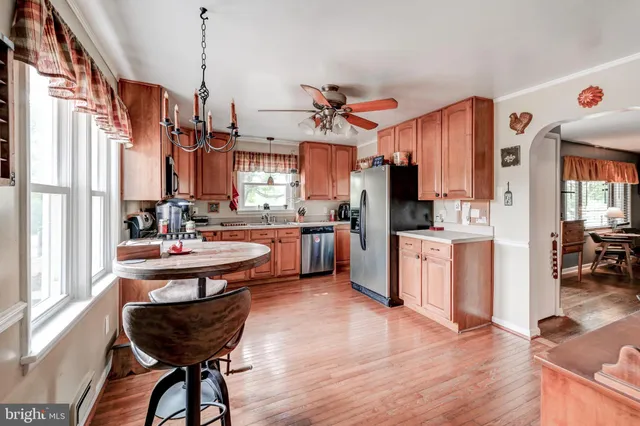 a kitchen with granite countertop a sink appliances and wooden floor