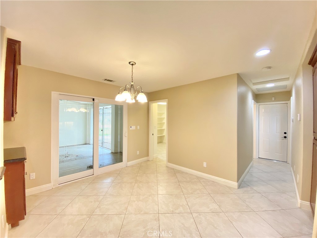 14670 Gilman Springs Road Moreno Valley, CA 92555 - Photo 13 of 50 a view of a hallway with wooden floor and chandelier