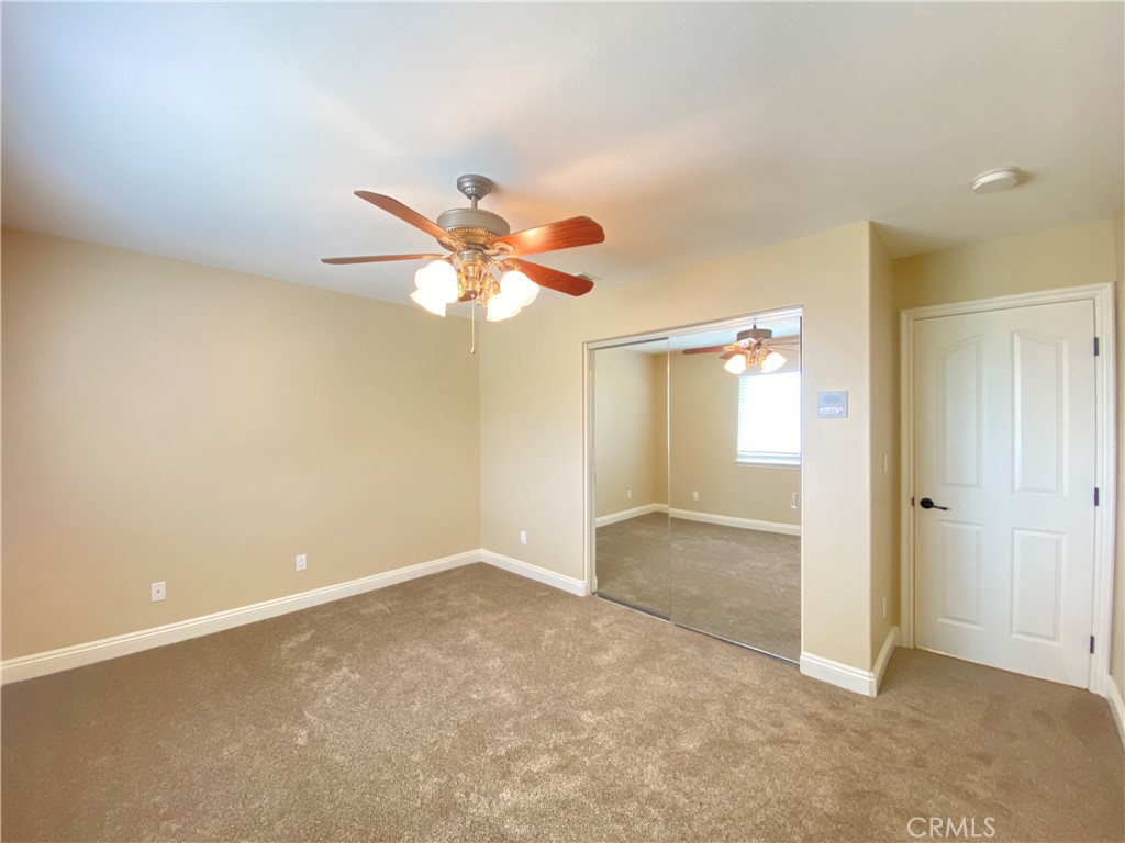 14670 Gilman Springs Road Moreno Valley, CA 92555 - Photo 21 of 50 an empty room with closet and a chandelier fan