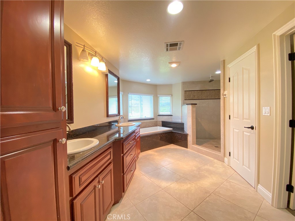 14670 Gilman Springs Road Moreno Valley, CA 92555 - Photo 40 of 50 a spacious bathroom with a granite countertop sink and a large mirror
