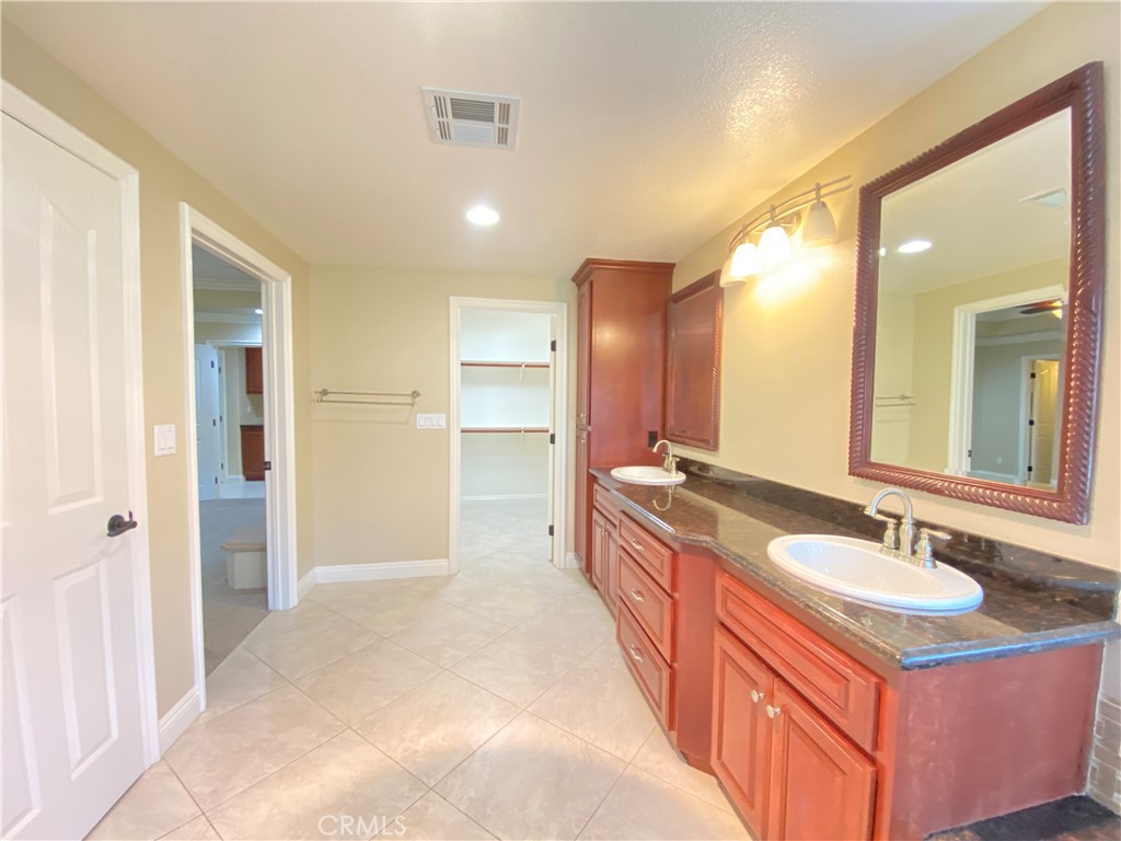 14670 Gilman Springs Road Moreno Valley, CA 92555 - Photo 42 of 50 a spacious bathroom with a double vanity sink and mirror