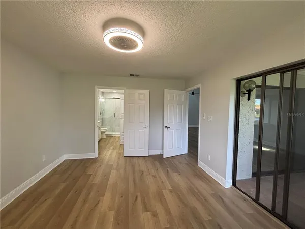 a view of empty room with wooden floor