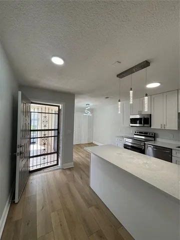 a view of a kitchen with a sink and dishwasher a oven with wooden floor