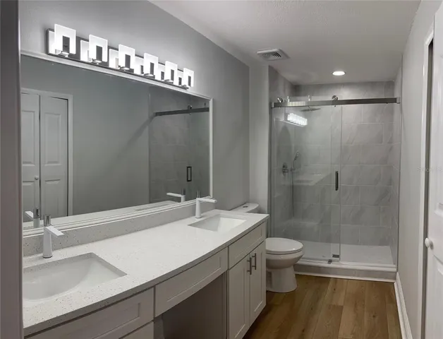 a bathroom with a sink a toilet and shower