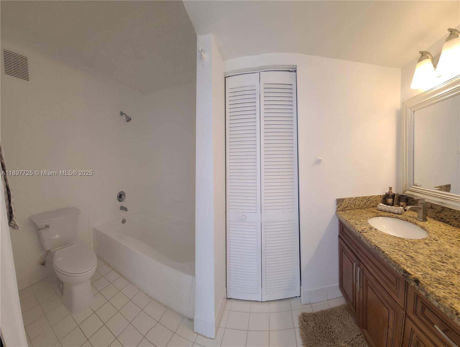 2133 Renaissance Boulevard, Unit 306 Miramar, FL 33025 - Photo 15 of 41 a spacious bathroom with a granite countertop sink a toilet and bathtub