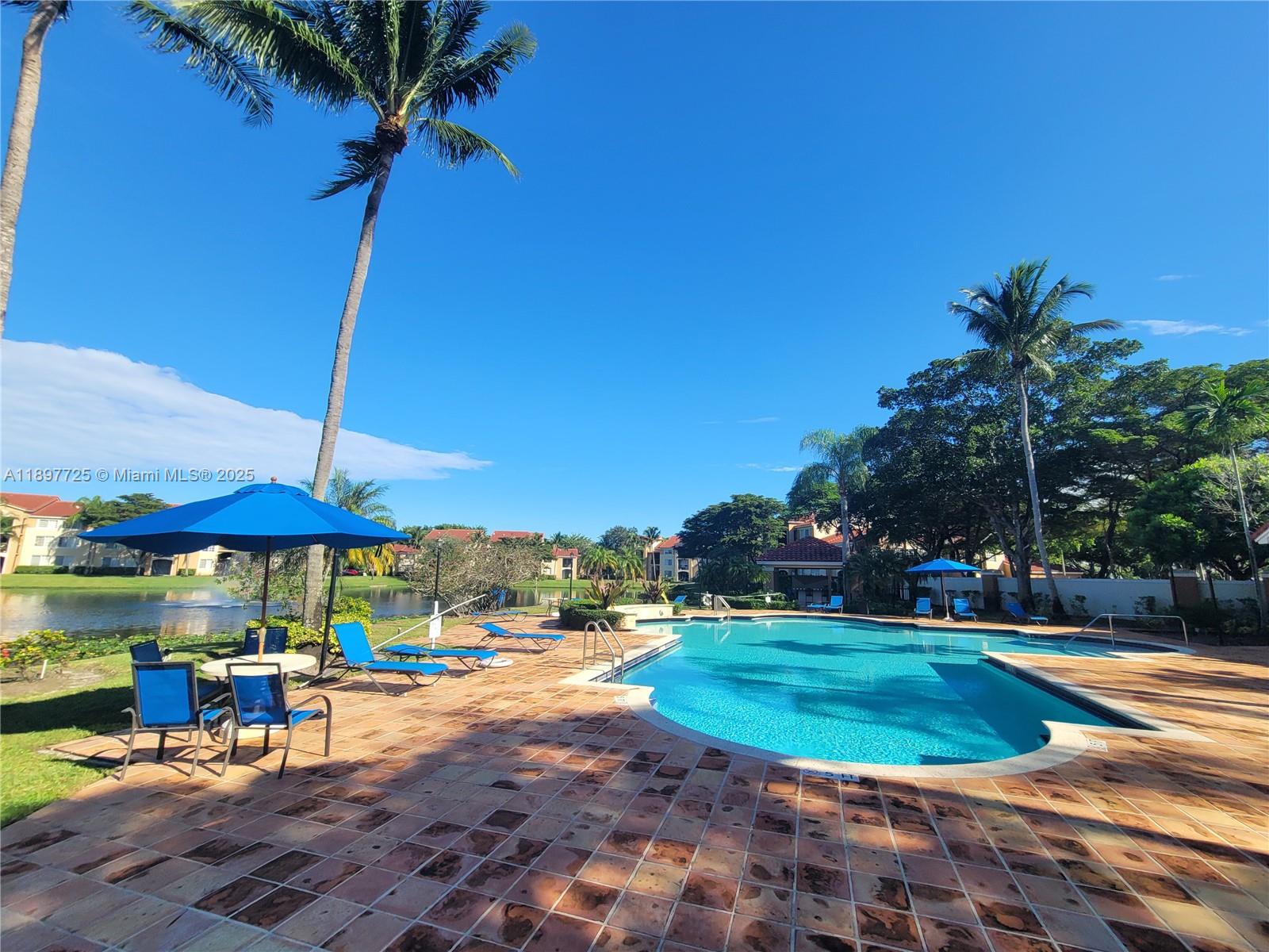 2133 Renaissance Boulevard, Unit 306 Miramar, FL 33025 - Photo 29 of 41 a view of a table and chairs under an umbrella
