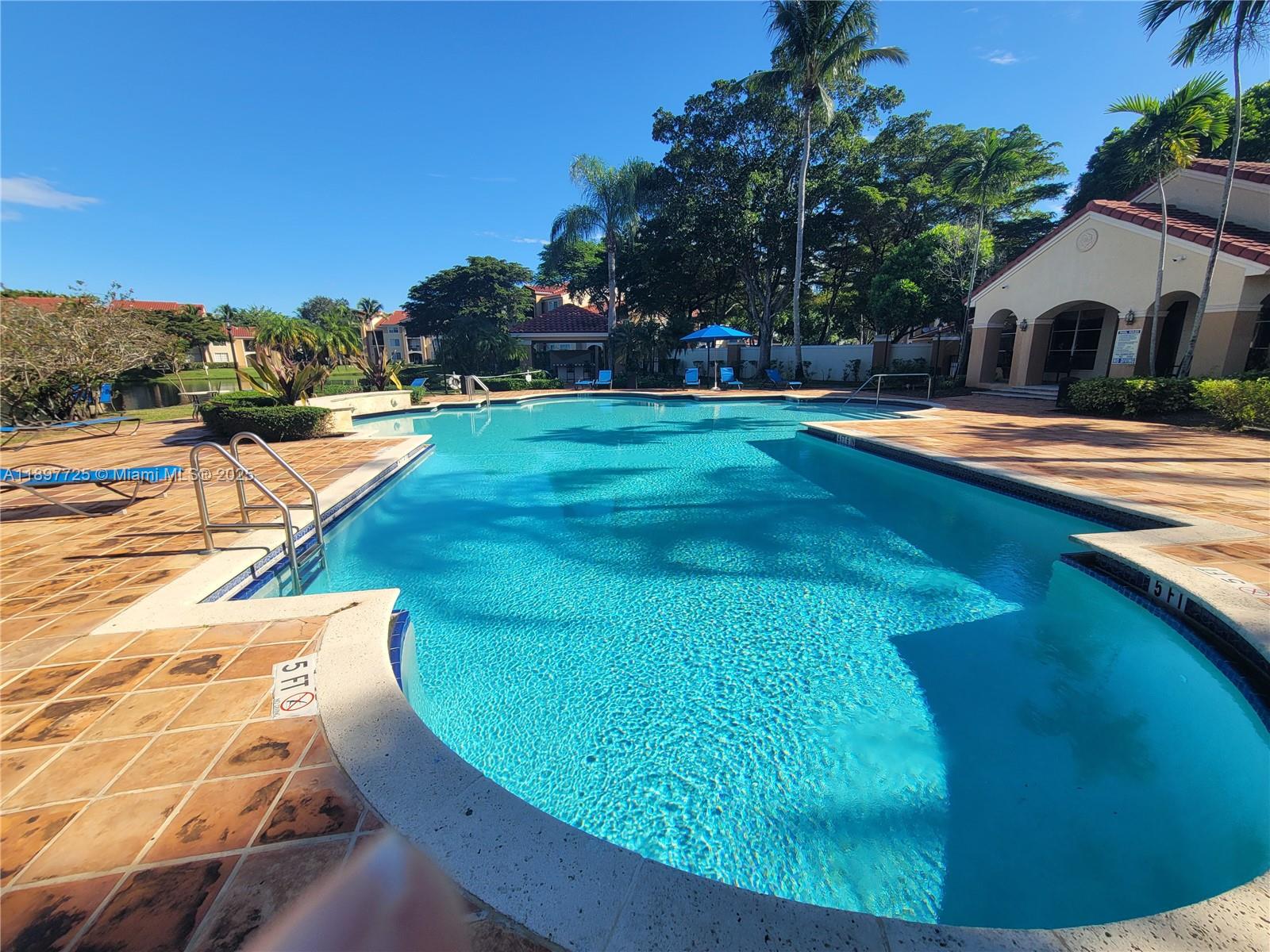 2133 Renaissance Boulevard, Unit 306 Miramar, FL 33025 - Photo 31 of 41 a swimming pool with outdoor seating and yard