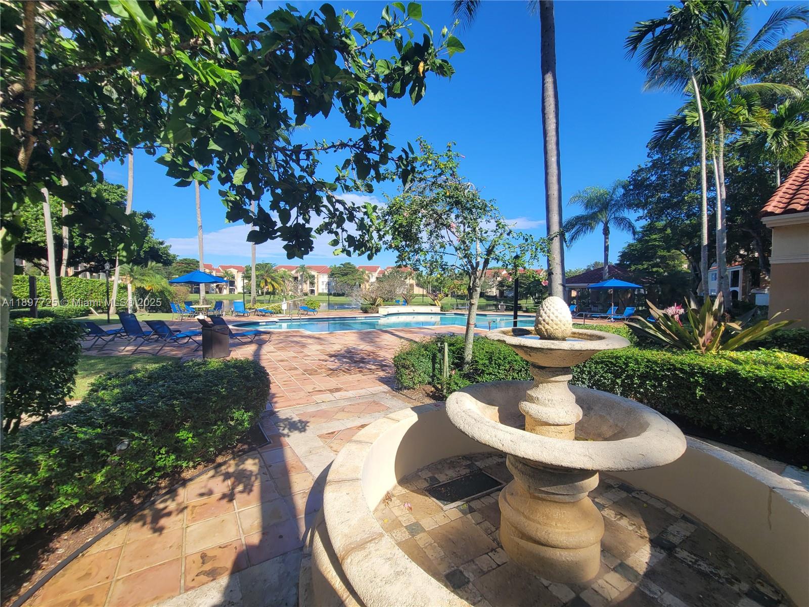 2133 Renaissance Boulevard, Unit 306 Miramar, FL 33025 - Photo 35 of 41 a view of a patio with table and chairs potted plants and palm trees