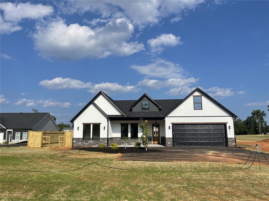424 Blume Road Anderson, SC 29625 - Photo 3 of 33 Modern farmhouse style home with striking black and white exterior against a vibrant blue sky.