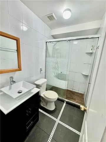 a bathroom with a double vanity sink toilet mirror and shower