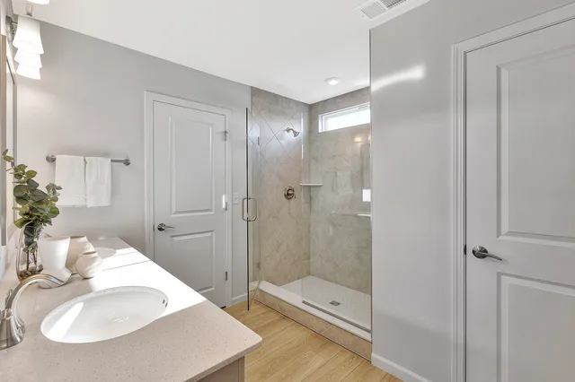 a bathroom with a sink shower and a mirror