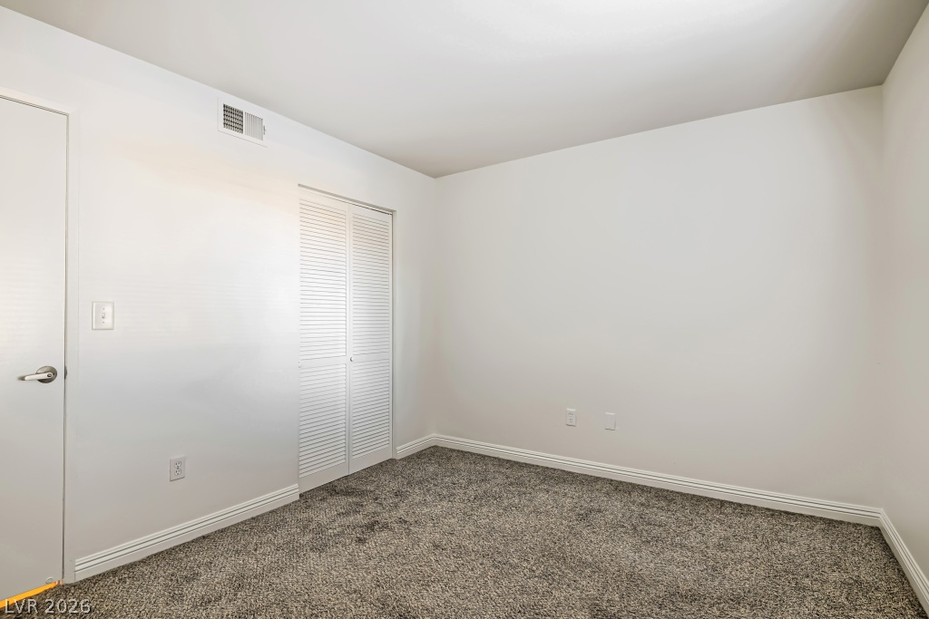 7885 West Flamingo Road, Unit 1003 Las Vegas, NV 89147 - Photo 18 of 22 Plush carpeting and fresh white walls define this versatile bedroom space.