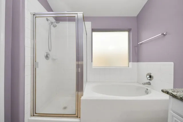 a bathroom with a granite countertop sink mirror and a bathtub