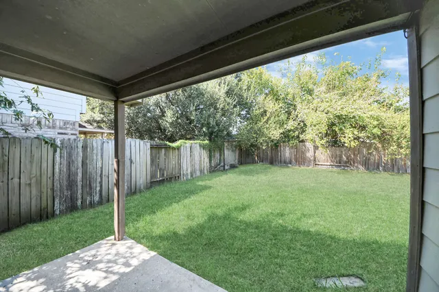 a view of a house with a big yard and large tree